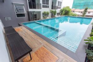una piscina con una mesa y una silla junto a un edificio en Large 2 Bedrooms/50m to MRT/Free Wifi/Full Kitchen, en Nonthaburi