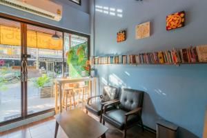 Habitación con silla, mesa y ventana en Phobphan Hostel, en Bangkok