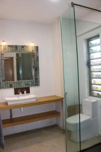 un bagno con un water, un lavandino e uno specchio di KEHA PROPERTIES a Flic-en-Flac
