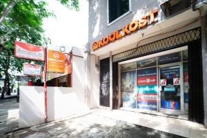 a store with a sign on the side of a building at KoolKost near RS Pelabuhan Jakarta - Minimum Stay 6 Nights in Jakarta