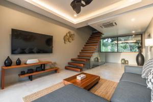 a living room with a blue couch and stairs at Zee Luxury Boutique Hotel in Hinkong