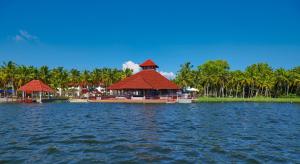 a resort with a building in the middle of a body of water at Estuary Sarovar Premiere , Poovar Island in Pūvār