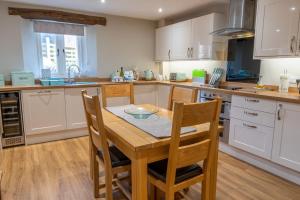 a kitchen with a wooden table and chairs at Drovers Cottage in Kendal