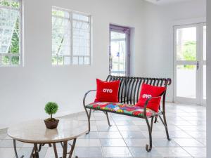 a bench in a room with two red pillows at OYO Hotel Cosmópolis, Sao Paulo in Cosmópolis