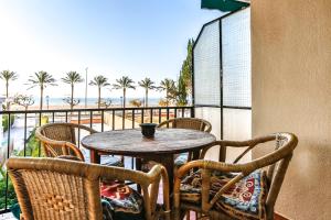 een tafel en stoelen op een balkon met uitzicht op het strand bij Vacaciones perfectas 2 in Segur de Calafell