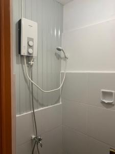 a shower with a hose in a bathroom at LR Hostel and Cafe in Moalboal +24 photos