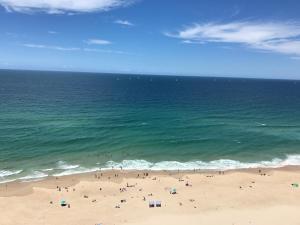 a beach with a bunch of people on it at Focus Apartments in Gold Coast