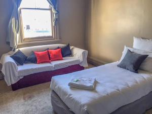 
a bedroom with a white bedspread and white pillows at Commercial Hotel Motel Lithgow in Lithgow
