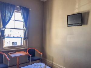 
a room with a television and a bed at Commercial Hotel Motel Lithgow in Lithgow
