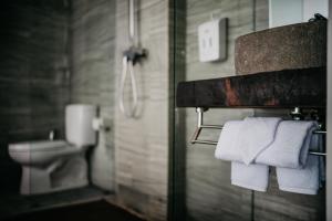 a bathroom with a toilet and white towels at Dreamland View in Uluwatu +29 photos