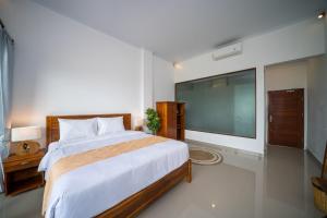 a bedroom with a large bed and a large screen television at Dreamland View in Uluwatu