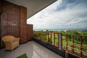 einen Balkon mit einem Stuhl und Aussicht in der Unterkunft Dreamland View in Uluwatu