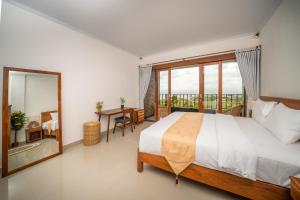 a bedroom with a large bed and a large window at Dreamland View in Uluwatu