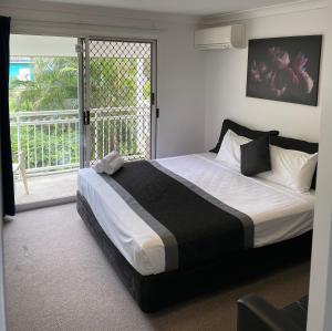 a bedroom with a bed and a window at Chermside Court Motel in Brisbane