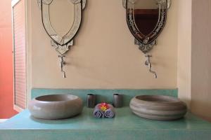 two sinks on a counter in a bathroom with mirrors at Villa Pondok Terra in Yogyakarta