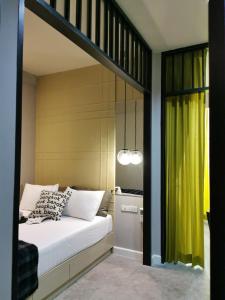 a bedroom with a bed with a yellow curtain at Chomm House in Bangkok