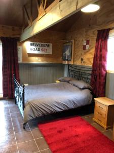 a bedroom with a bed and a red rug at The Lodge in Bedford