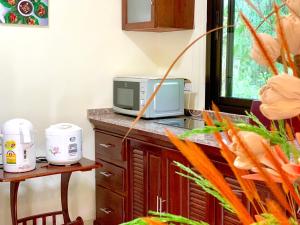 a kitchen with a microwave and a counter with carrots at Kannapat House in Ban Nong Thale