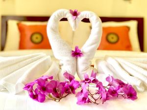 two swans making a heart shape on a bed at Kannapat House in Ban Nong Thale