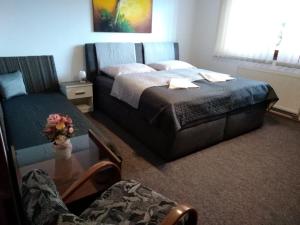 a bedroom with a bed and a table and a couch at Brezno 2 izbovy Apartman Sabi in Brezno