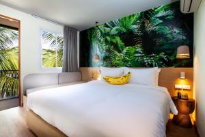 um quarto com uma cama grande e uma banana na parede em The Stay Chaweng Beach Resort- SHA Plus em Chaweng