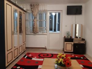 sala de estar con mesa y TV en la pared en Florin Apartament, en Sighişoara