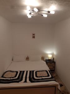 1 dormitorio con 1 cama con manta blanca y negra en Florin Apartament, en Sighişoara