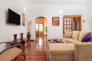 un salon avec un canapé et une télévision dans l'établissement Casa Laura, à La Ampuyenta