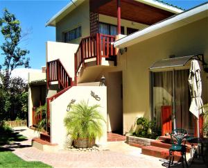 a house with a palm tree in front of it at Cedar Lodge Guest House in Robertson