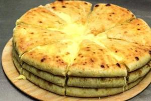 a pizza sitting on top of a wooden plate at MY HOUSE in Batumi