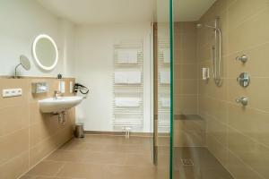 y baño con ducha y lavamanos. en ANA Living Augsburg City Center by Arthotel ANA - Self-Service-Hotel, en Augsburg