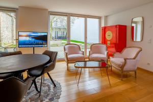 ein Wohnzimmer mit einem Tisch und Stühlen sowie einem roten Schrank in der Unterkunft ANA Living Augsburg City Center by Arthotel ANA - Self-Service-Hotel in Augsburg