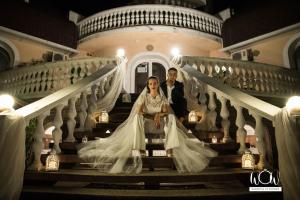 a bride and groom sitting on the stairs of a mansion at Káptalan vendégház in Balatonalmádi