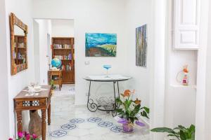 a living room with a table in the middle of a room at Pink liberty house in Santa Croce Camerina