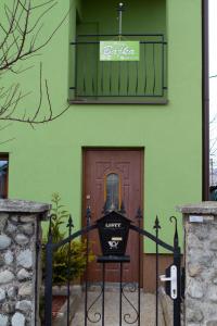 un edificio verde con una puerta con un cartel. en Privat BAJKA, en Spišské Bystré