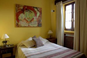 1 dormitorio con 1 cama y una pintura en la pared en Hostal Rural Elosta en Lekunberri