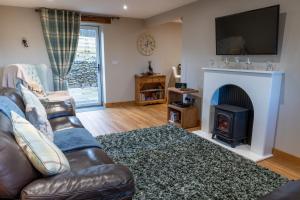 a living room with a couch and a fireplace at Drovers Cottage in Kendal
