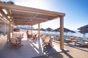 a patio with tables and chairs on the beach at Mitsis Selection Blue Domes in Kardamaina