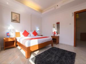 a bedroom with a bed with red and white sheets at Mirage Hotel in Dibba