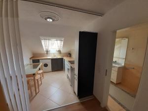 uma pequena cozinha com um lavatório e uma mesa em Apartment City Metzingen em Reutlingen