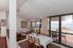 ein Esszimmer mit einem Tisch und Meerblick in der Unterkunft Apartments Kisic in Mlini