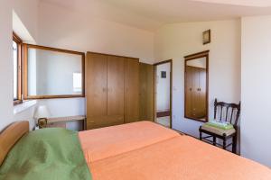 ein Schlafzimmer mit einem Bett und einem Stuhl darin in der Unterkunft Apartments Kisic in Mlini