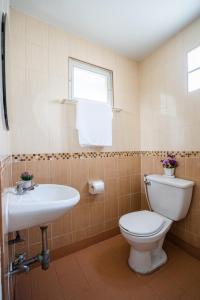 a bathroom with a toilet and a sink at Burapha Bangsaen Garden Apartment in Bangsaen