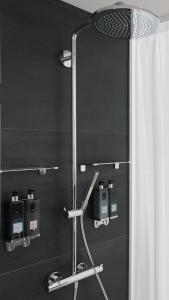 a shower in a bathroom with a black wall at Ruby Lucy Hotel London in London