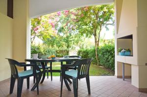 una sala da pranzo con tavolo e sedie su un patio di Villaggio Marco Polo a Bibione