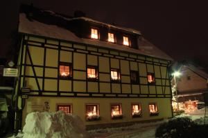 a black and white building with lights in the windows at Dreibettzimmer-in-Wiesa in Thermalbad Wiesenbad
