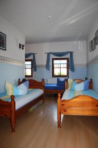 a room with three beds and two windows at Dreibettzimmer-in-Wiesa in Thermalbad Wiesenbad