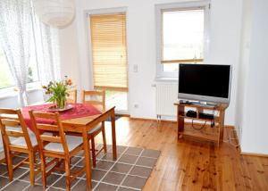 a living room with a table and a television at Unsere Ferienwohnung Stefan im Riesengebirge! in Dolní Lánov