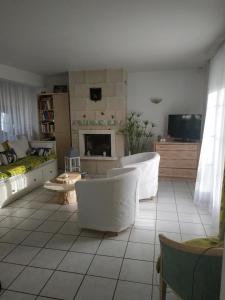 CHEZ MARLYSE في بلوا: غرفة معيشة بأثاث أبيض وموقد