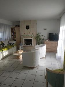 een woonkamer met witte meubels en een open haard bij CHEZ MARLYSE in Blois